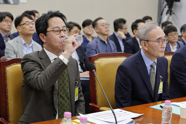 조좌진 롯데카드 대표이사가 24일 서울 여의도 국회 과학기술정보방송통신위원회에서 열린 대규모 해킹사고(통신·금융) 관련 청문회에서 목을 축이고 있다. 오른쪽은 김영섭 KT 대표이사. / 뉴스1