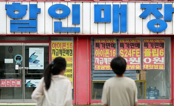 시민들이 7월 20일 오후 서울 시내 한 핸드폰 매장 앞을 지나가고 있다. / 뉴스1