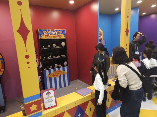 엄마와 함꼐 온 어린이 관람객이 웹젠 부스에서 공을 던져 타깃을 넘어뜨리는 타깃 스매시를 체험하고 있다. / 천선우 기자